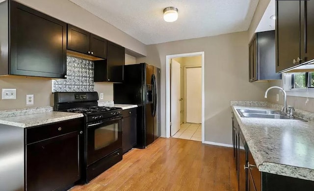 1919 Castle Gate Cir, San Marcos, TX 78666 - kitchen with black appliances, a sink, light countertops, light wood-type flooring, and baseboards