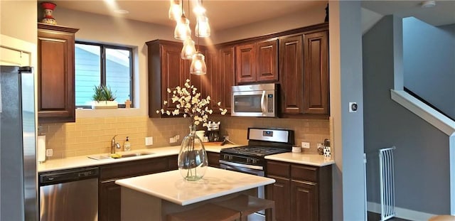2020 Tripshaw Ln Unit 65C, Austin, TX 78741 - kitchen with stainless steel appliances, a sink, backsplash, light countertops, and pendant lighting