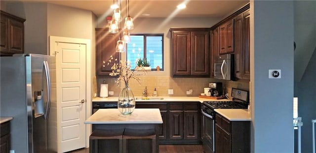 2020 Tripshaw Ln Unit 65C, Austin, TX 78741 - kitchen featuring stainless steel appliances, light countertops, tasteful backsplash, dark brown cabinetry, and a kitchen island