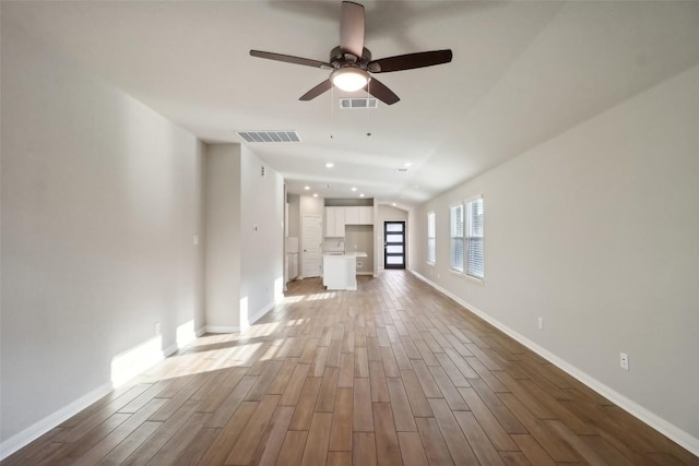825 Sun Grove Trl, Georgetown, TX 78628 - unfurnished living room featuring wood finished floors, a ceiling fan, baseboards, recessed lighting, and vaulted ceiling