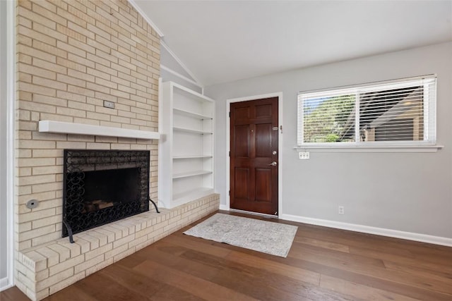 8500 Woodstone Dr, Austin, TX 78757 - unfurnished living room featuring lofted ceiling, wood finished floors, baseboards, built in shelves, and a fireplace