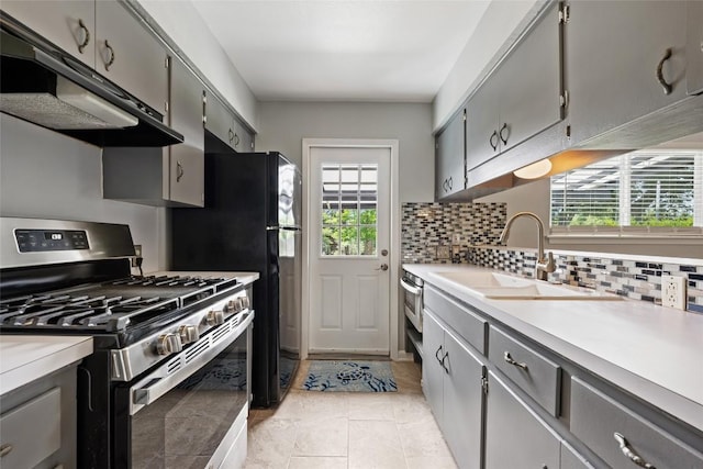 8500 Woodstone Dr, Austin, TX 78757 - kitchen featuring stainless steel range with gas cooktop, exhaust hood, gray cabinets, and healthy amount of natural light