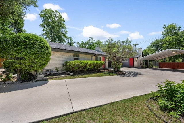 8500 Woodstone Dr, Austin, TX 78757 - view of front of house with a detached carport, fence, driveway, and brick siding