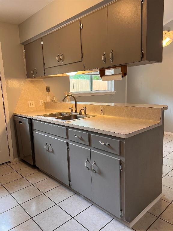 8500 Woodstone Dr, Austin, TX 78757 - kitchen featuring dishwasher, a sink, light tile patterned floors, light countertops, and gray cabinets