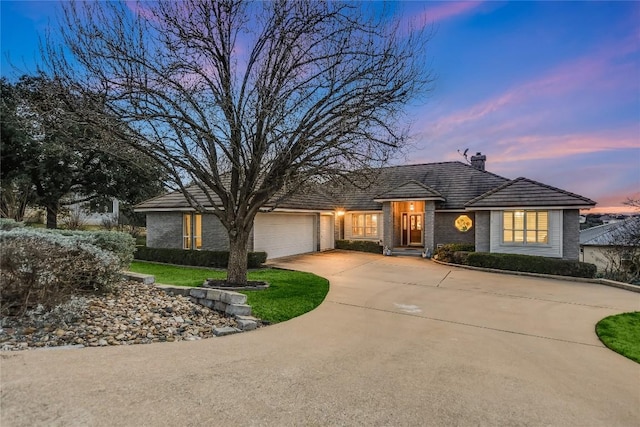 1310 Clayton Nolen, Horseshoe Bay, TX 78657 - view of front of property featuring a chimney, concrete driveway, a garage, and brick siding
