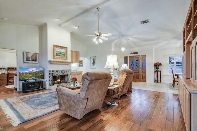 1310 Clayton Nolen, Horseshoe Bay, TX 78657 - living room featuring wood finished floors, a tiled fireplace, a ceiling fan, and high vaulted ceiling