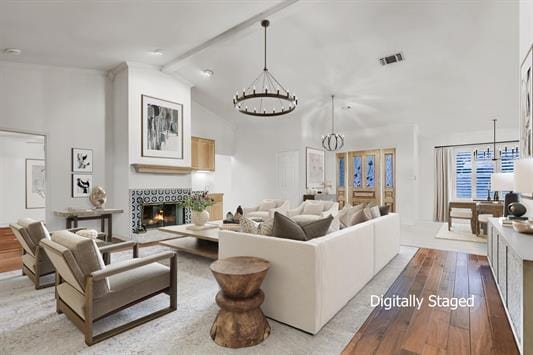 1310 Clayton Nolen, Horseshoe Bay, TX 78657 - living area with a chandelier, a warm lit fireplace, hardwood / wood-style floors, high vaulted ceiling, and beamed ceiling