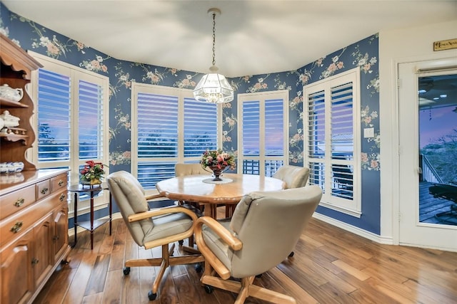 1310 Clayton Nolen, Horseshoe Bay, TX 78657 - dining space with wallpapered walls, a chandelier, wood finished floors, and baseboards