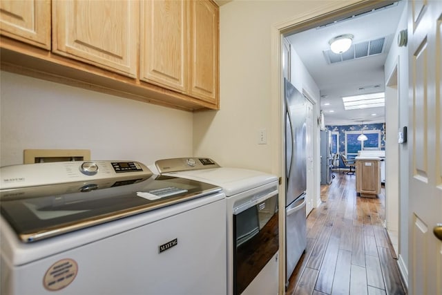 1310 Clayton Nolen, Horseshoe Bay, TX 78657 - laundry room featuring cabinet space, washing machine and dryer, and wood finished floors