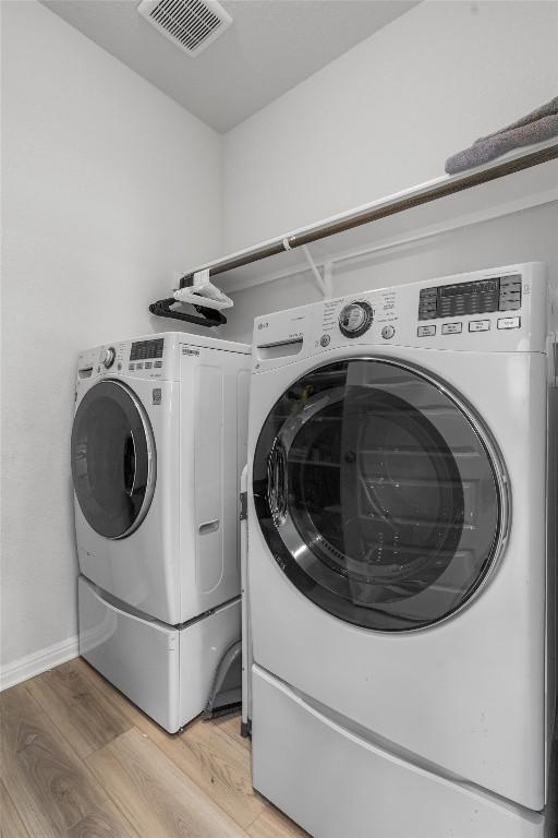 224 Backstays Loop, Kyle, TX 78640 - clothes washing area with washing machine and dryer, light wood-style floors, and baseboards