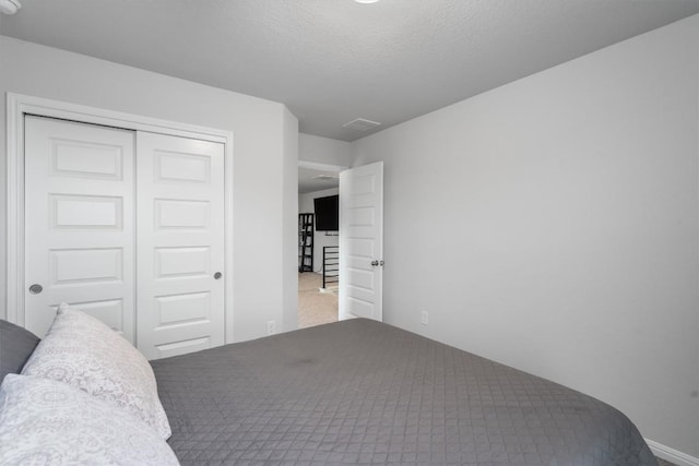 224 Backstays Loop, Kyle, TX 78640 - bedroom featuring a closet, carpet flooring, and a textured ceiling