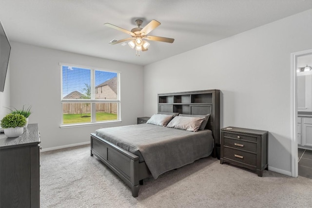 224 Backstays Loop, Kyle, TX 78640 - bedroom featuring light colored carpet, baseboards, ensuite bath, and a ceiling fan