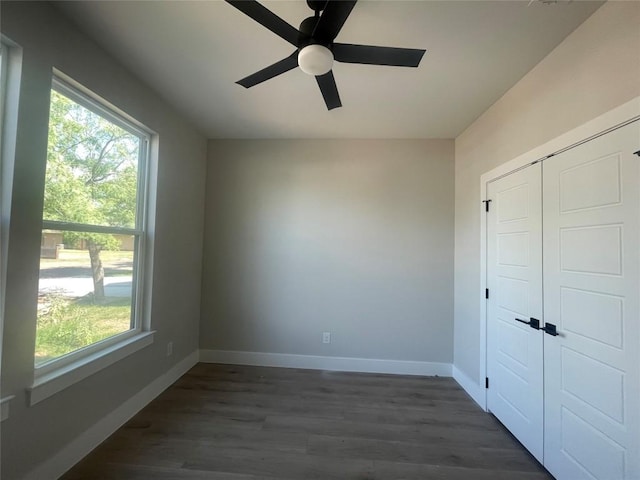 650 Birch Ln, Cottonwood Shores, TX 78657 - unfurnished bedroom with multiple windows, baseboards, and dark wood-style floors