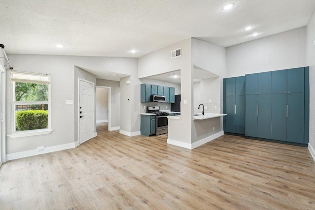 kitchen with appliances with stainless steel finishes, light wood-type flooring, light countertops, baseboards, and recessed lighting