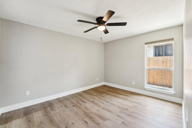 unfurnished room with wood finished floors, ceiling fan, and baseboards