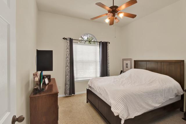 1040 Kensington Castle Trl, Pflugerville, TX 78660 - bedroom with light colored carpet and ceiling fan