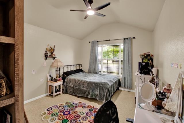 1040 Kensington Castle Trl, Pflugerville, TX 78660 - carpeted bedroom with lofted ceiling and ceiling fan