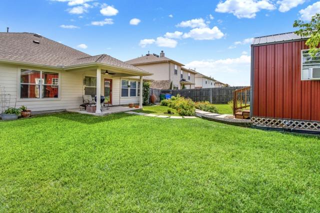 1040 Kensington Castle Trl, Pflugerville, TX 78660 - back of property with ceiling fan, a fenced backyard, a patio area, and a shed