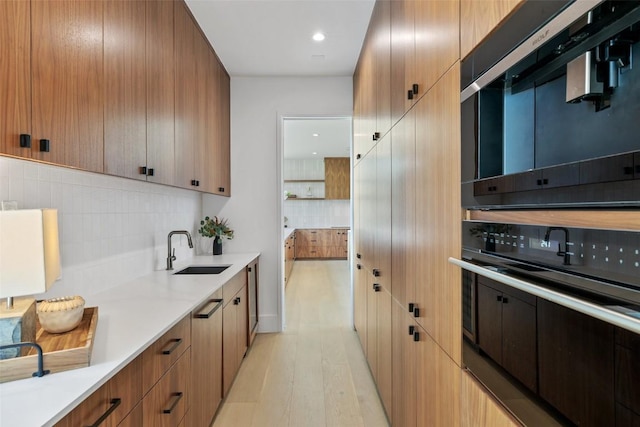 1604 Barclay Dr, Austin, TX 78746 - kitchen with oven, a sink, tasteful backsplash, light countertops, and light wood-type flooring