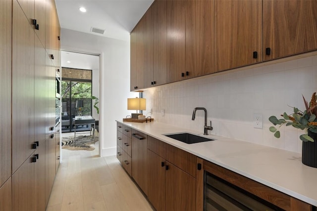 1604 Barclay Dr, Austin, TX 78746 - kitchen featuring a sink, light countertops, decorative backsplash, light wood-style floors, and recessed lighting