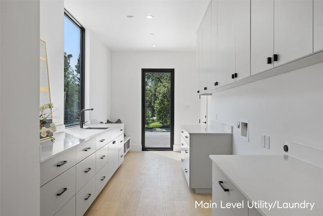 1604 Barclay Dr, Austin, TX 78746 - washroom featuring cabinet space, hookup for an electric dryer, hookup for a washing machine, light wood-style floors, and recessed lighting