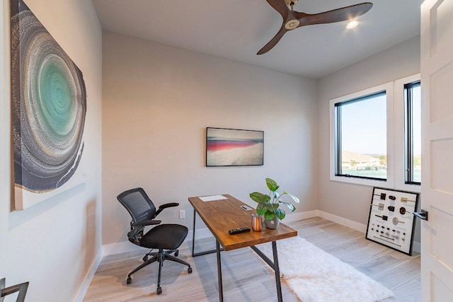 office featuring light wood-style flooring, ceiling fan, and baseboards