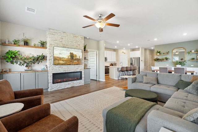 1116 View Dr, Georgetown, TX 78628 - living room with ceiling fan, light wood-style floors, a stone fireplace, and recessed lighting