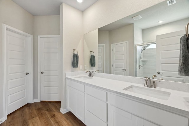 1116 View Dr, Georgetown, TX 78628 - full bathroom featuring a shower stall, double vanity, wood finished floors, and recessed lighting