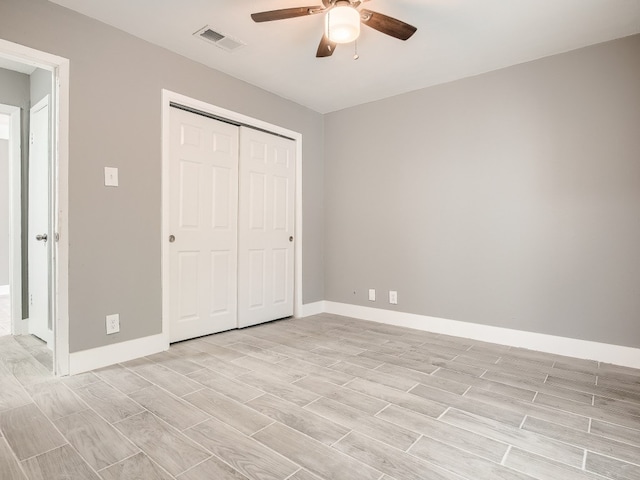 unfurnished bedroom featuring wood tiled floors, baseboards, and a closet