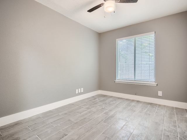 unfurnished room featuring light wood-type flooring, ceiling fan, and baseboards
