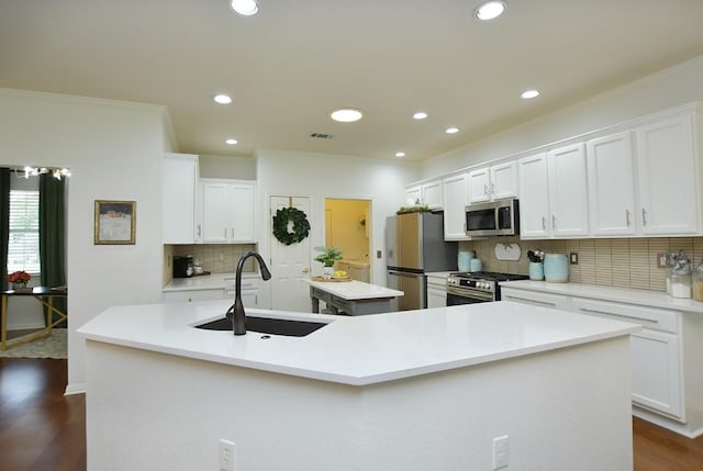 101 Scurry Pass, Georgetown, TX 78633 - kitchen with stainless steel appliances, a sink, a center island with sink, backsplash, and dark wood-style flooring