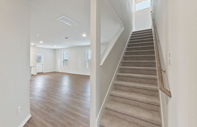 staircase featuring wood finished floors, recessed lighting, and baseboards