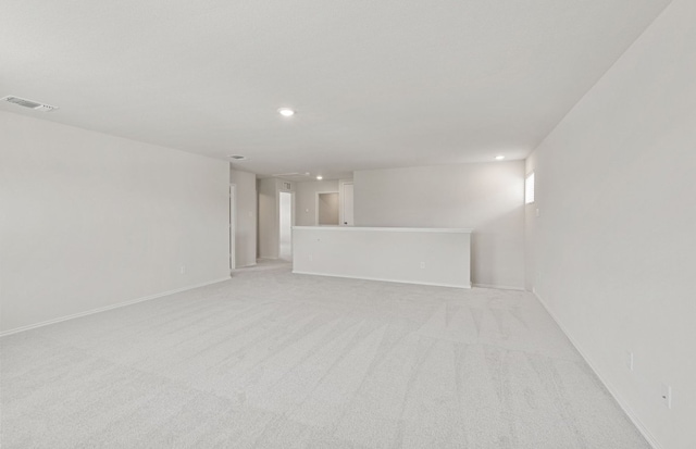 unfurnished living room with recessed lighting, light carpet, and baseboards