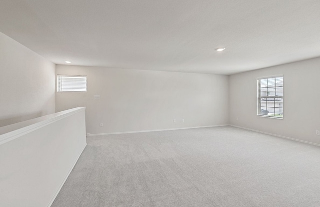 empty room featuring recessed lighting, light colored carpet, and baseboards