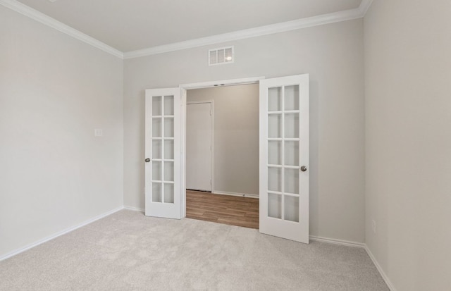 carpeted spare room with french doors, crown molding, and baseboards