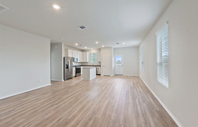 unfurnished living room with light wood-style flooring, baseboards, and recessed lighting