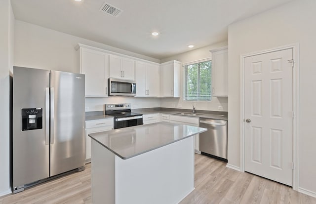 kitchen with stainless steel appliances, a sink, light wood-style floors, white cabinetry, and recessed lighting