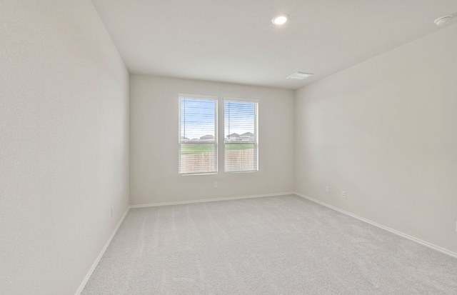 unfurnished room with baseboards, light carpet, and recessed lighting