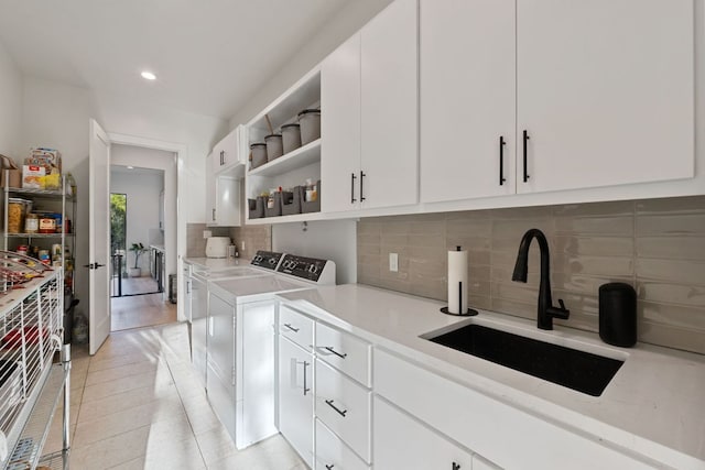 1769 Parten Ranch Pkwy, Austin, TX 78737 - kitchen with a sink, independent washer and dryer, open shelves, backsplash, and white cabinetry