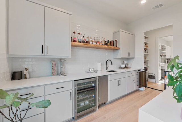 1769 Parten Ranch Pkwy, Austin, TX 78737 - indoor wet bar with beverage cooler, light wood-type flooring, backsplash, and recessed lighting