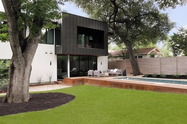 rear view of property featuring outdoor lounge area and a balcony