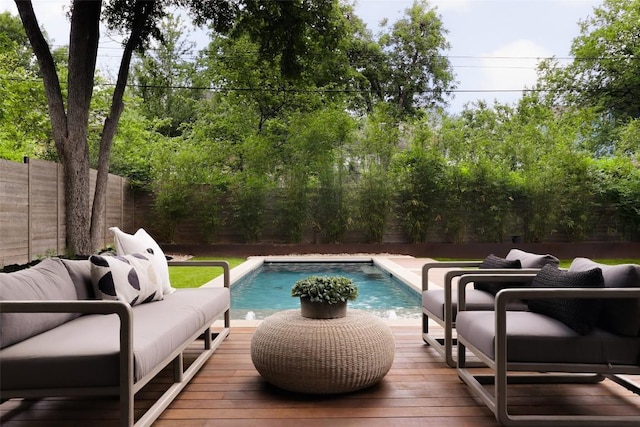 view of swimming pool featuring a fenced backyard, outdoor lounge area, and a wooden deck