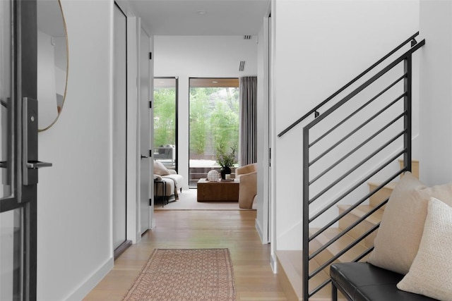 hall featuring light wood-type flooring and stairway