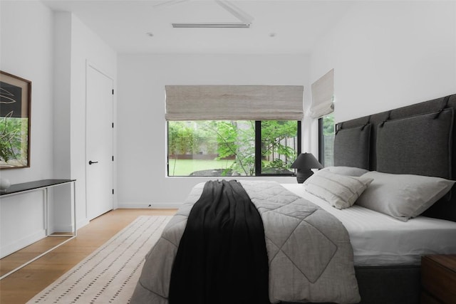 bedroom with light wood-type flooring and baseboards