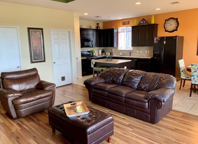 living area featuring light wood finished floors and recessed lighting