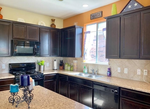 kitchen with black appliances, a sink, dark brown cabinets, and backsplash