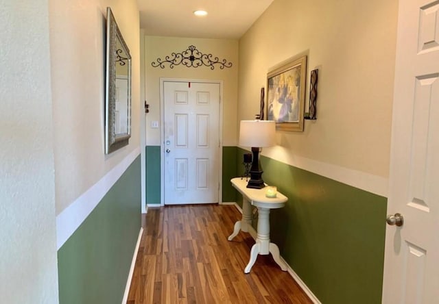 doorway with wood finished floors and baseboards