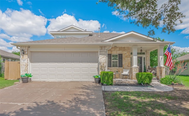 107 Wisteria Way, San Marcos, TX 78666 - view of front facade with a porch, stone siding, concrete driveway, a garage, and roof with shingles