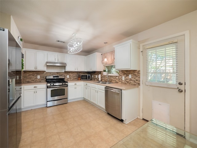 107 Wisteria Way, San Marcos, TX 78666 - kitchen featuring appliances with stainless steel finishes, a chandelier, tasteful backsplash, and light countertops