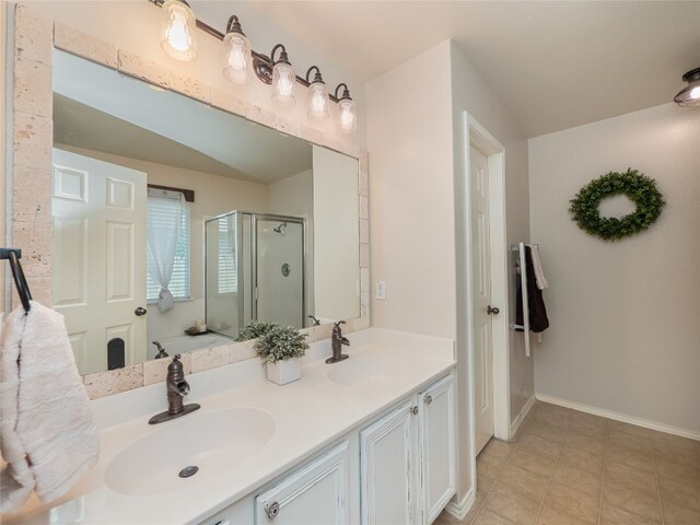 107 Wisteria Way, San Marcos, TX 78666 - full bathroom with a stall shower, double vanity, tile patterned floors, and baseboards
